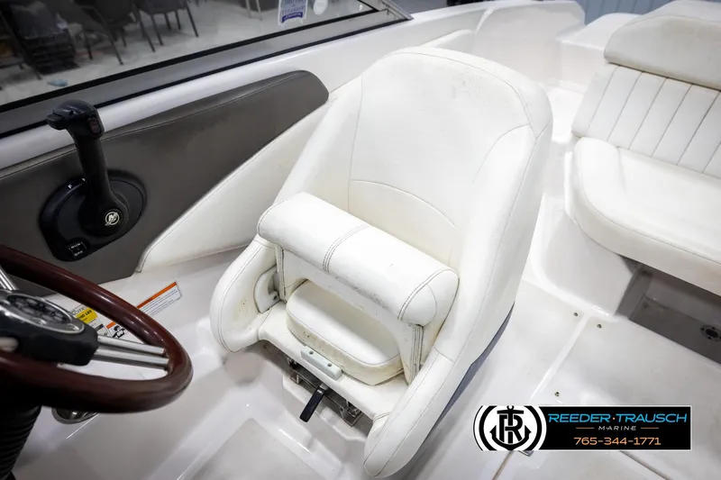 Slide: The Image of White captain's seat in 2008 Regal 1900 boat, featuring steering wheel and control panel. - 22