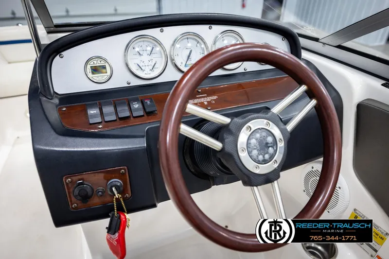 Slide: The Image of Steering wheel and dashboard of a 2008 Regal 1900 boat with gauges and controls. - 24