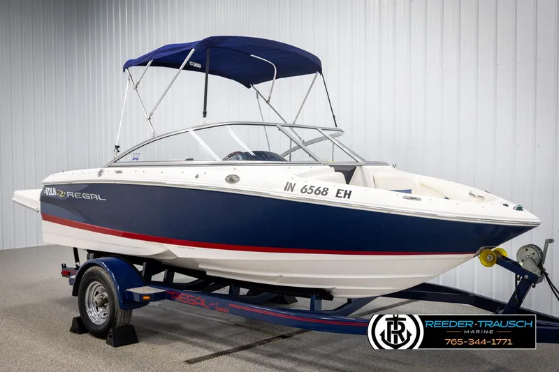 Slide: The Image of 2008 Regal 1900 boat with blue and white design on a trailer in a showroom. - 3