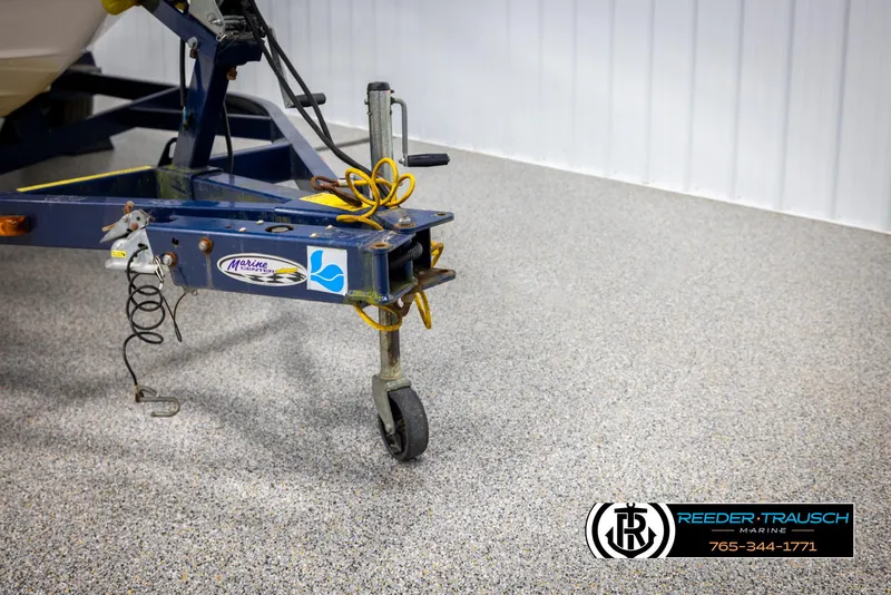 Slide: The Image of Trailer hitch of a 2008 Regal 1900 boat on a speckled garage floor. - 49