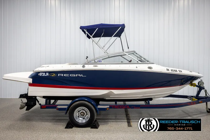 Slide: The Image of 2008 Regal 1900 boat with blue and white design on a trailer in a showroom. - 5