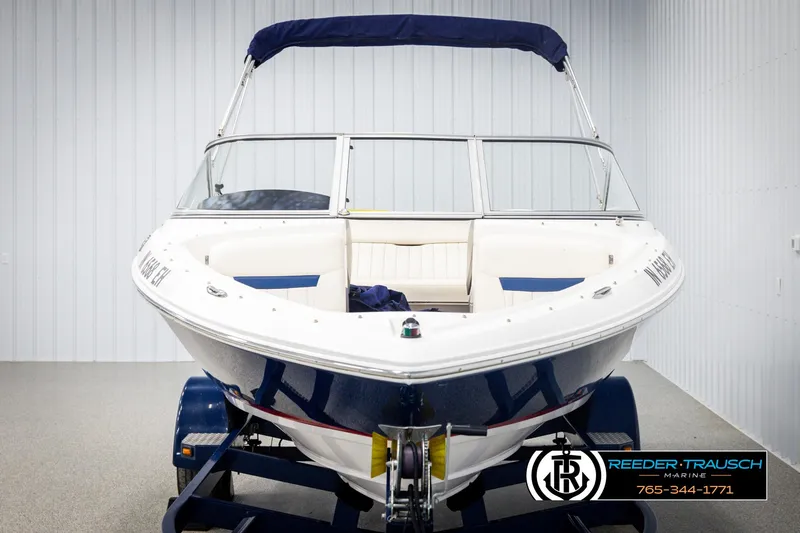 Slide: The Image of 2008 Regal 1900 boat with blue canopy on trailer in showroom. - 8