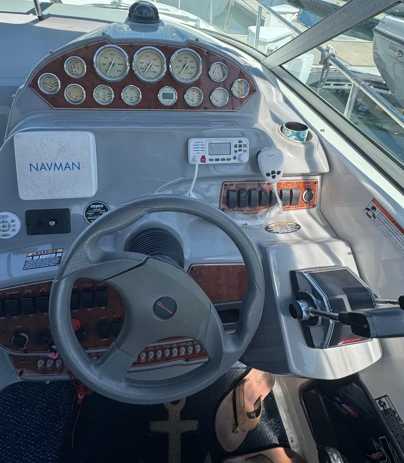 Slide: The Image of 2006 Bayliner 325 boat dashboard with steering wheel, gauges, and navigation controls. - 13