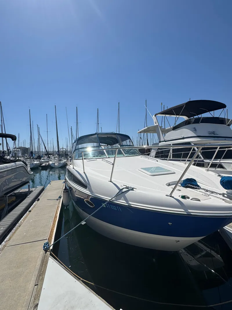 Slide: The Image of 2006 Bayliner 325 yacht docked at marina under clear blue sky. - 2