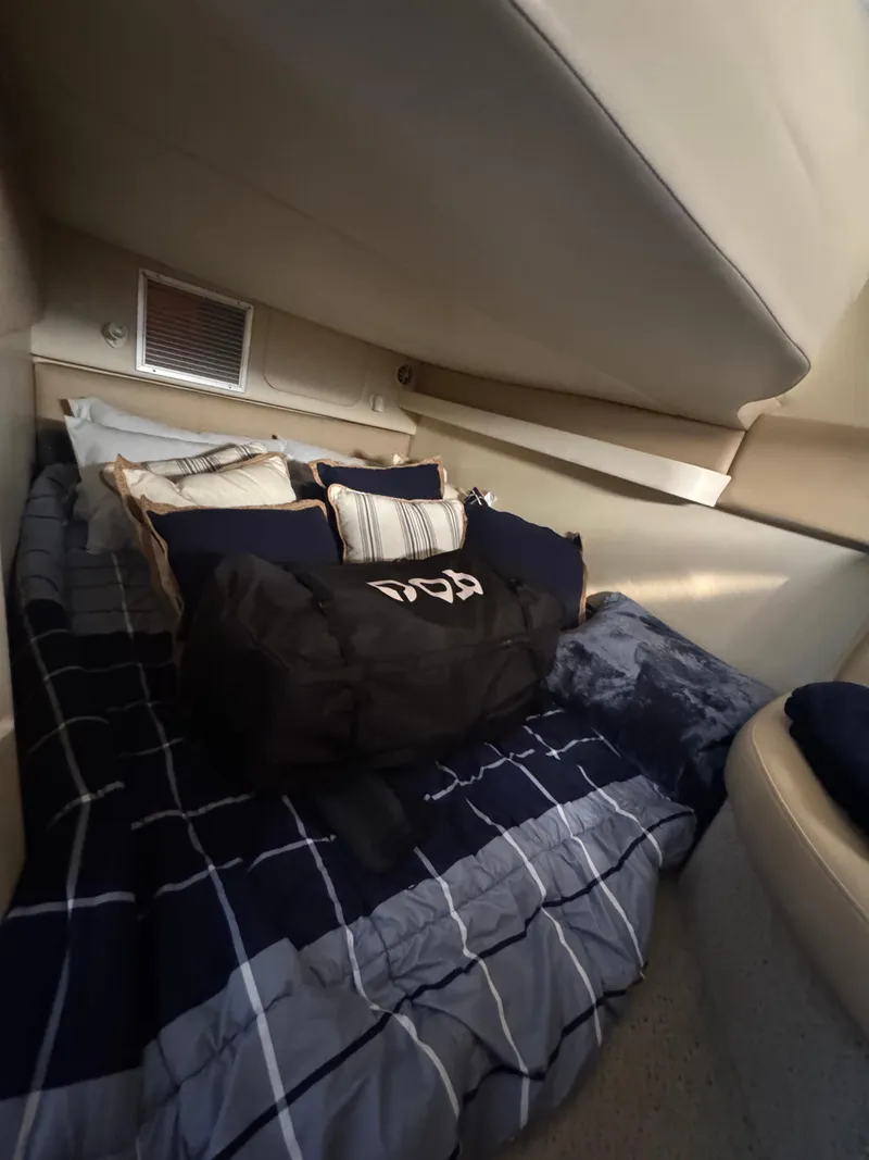 Slide: The Image of 2006 Bayliner 325 cabin interior with cozy bedding and pillows. - 20