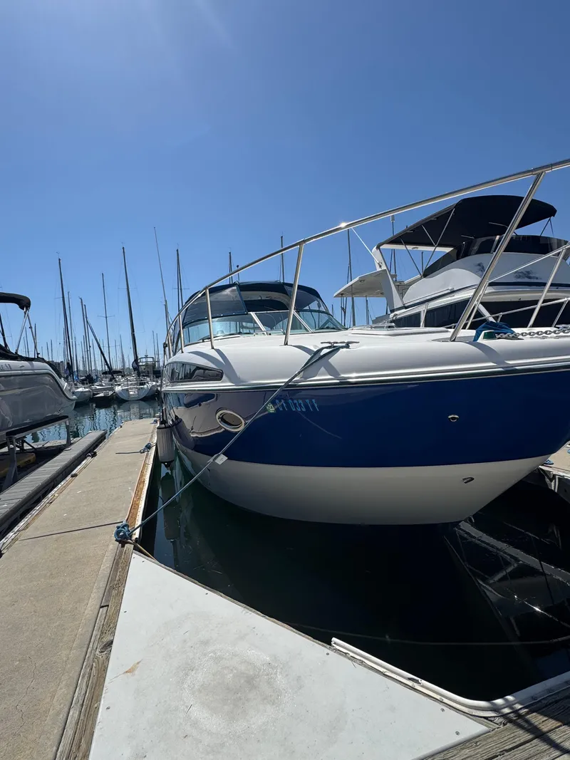 Slide: The Image of 2006 Bayliner 325 boat docked at a marina under clear blue skies. - 3