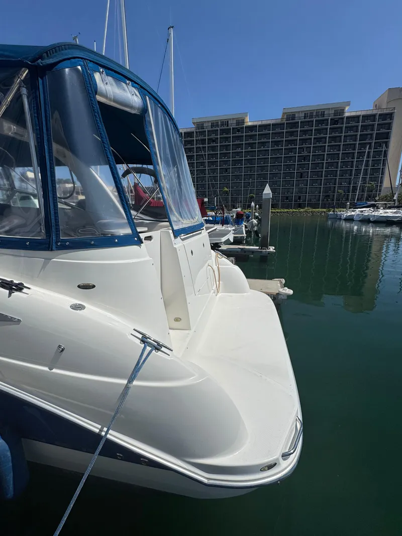 Slide: The Image of 2006 Bayliner 325 docked at marina with modern buildings in background. - 5