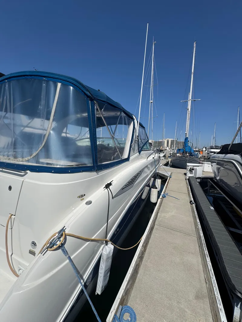 Slide: The Image of 2006 Bayliner 325 yacht docked at marina under clear blue sky. - 6
