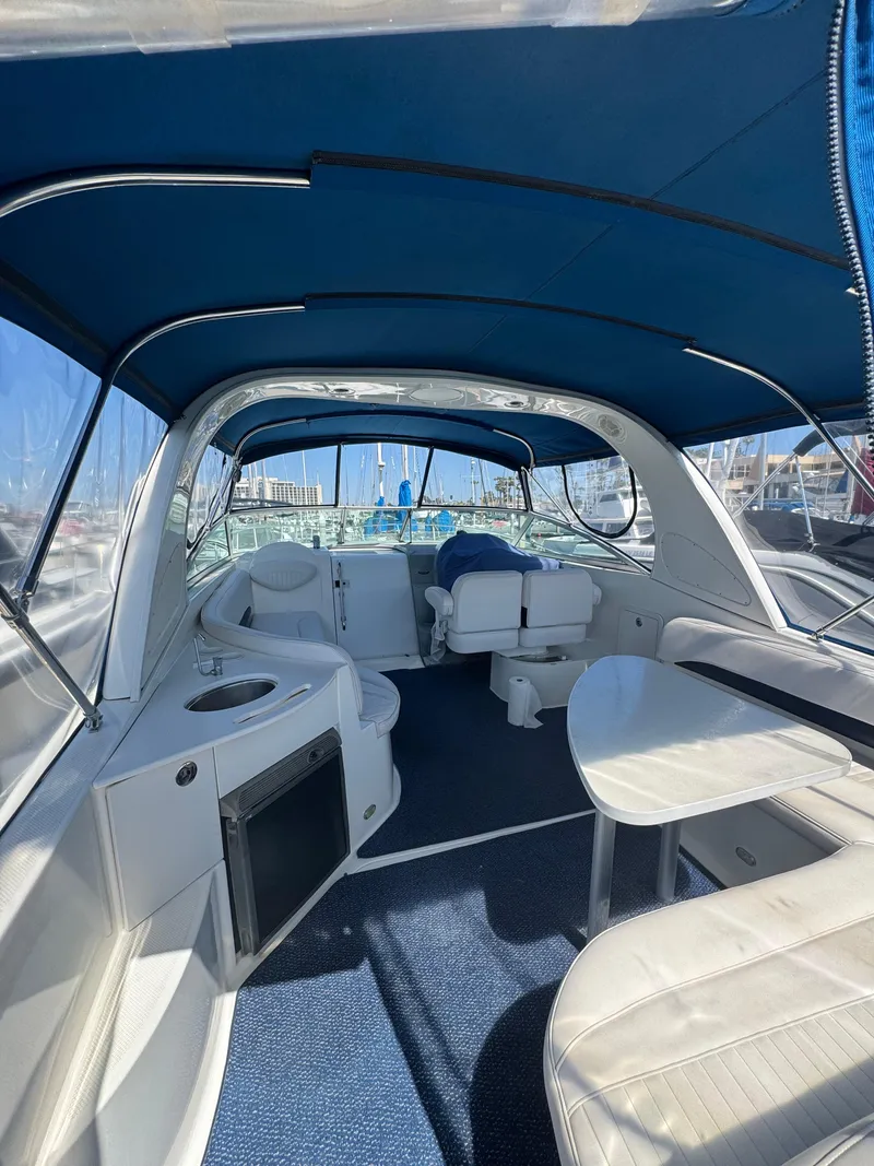 Slide: The Image of 2006 Bayliner 325 boat interior with blue canopy and seating area. - 8