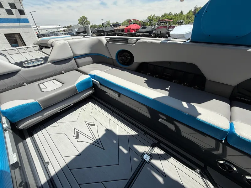 Slide: The Image of 2020 Supra SE550 boat interior with gray and blue seating, modern design, and spacious layout. - 14