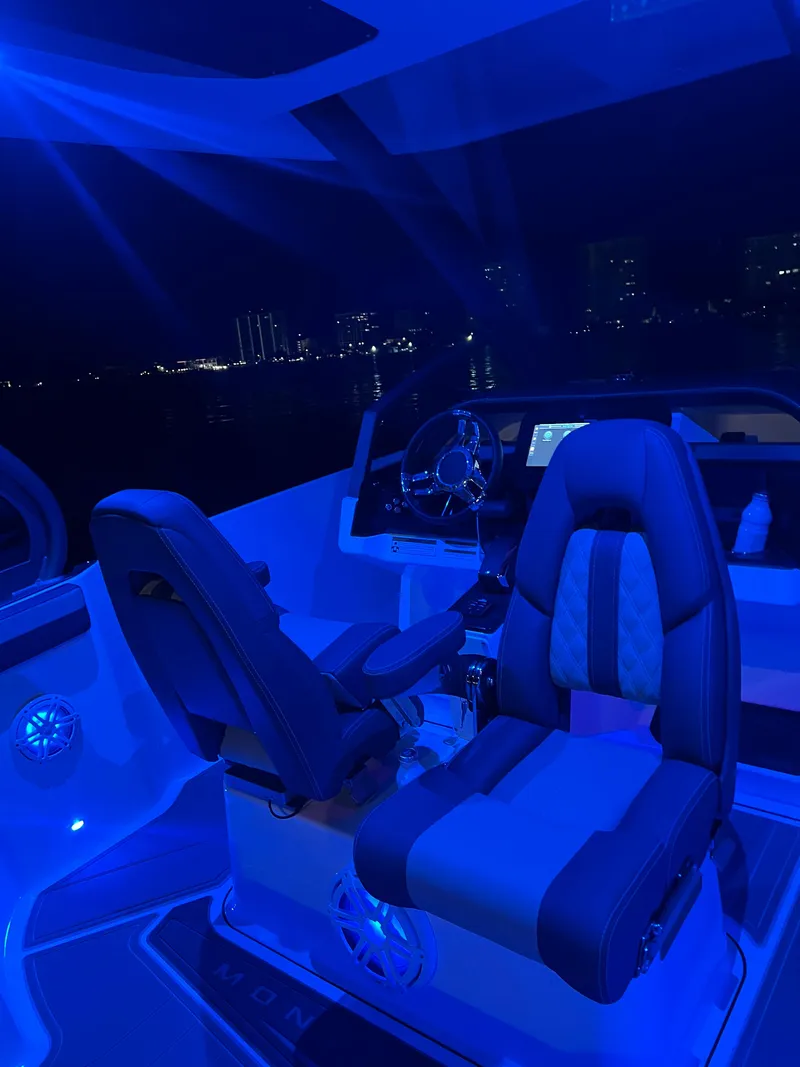 Slide: The Image of Luxurious 2026 Monterey Elite 27 boat interior with blue ambient lighting at night. - 1