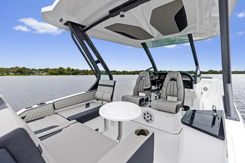Slide: The Image of 2025 Monterey Elite 27 boat interior with modern seating and sleek design on a calm lake. - 5