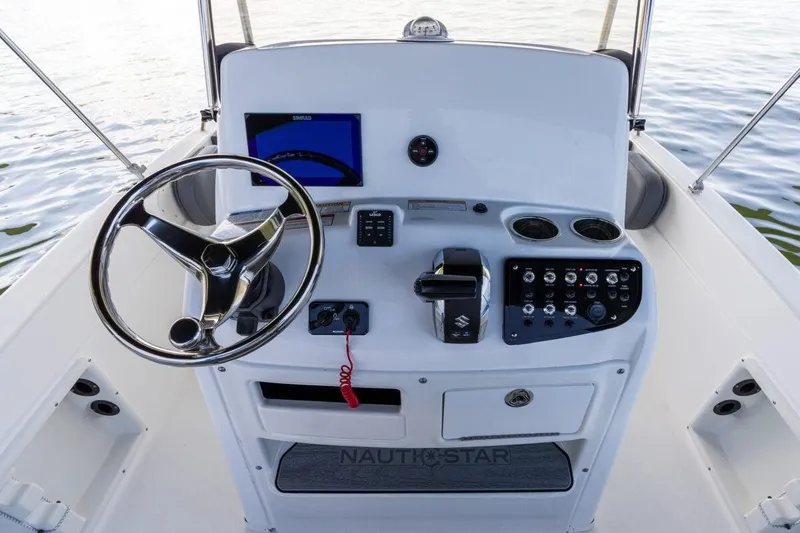 Slide: The Image of 2020 NauticStar 211 Hybrid boat docked by waterfront homes. - 5