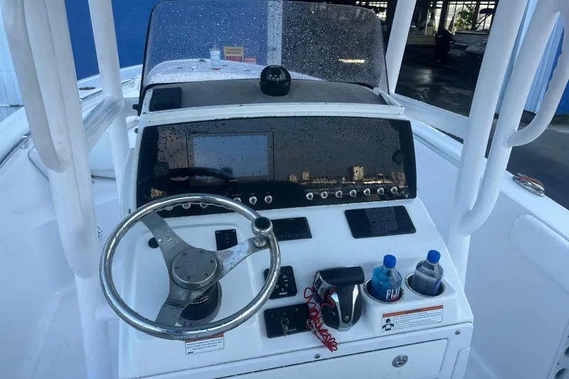Slide: The Image of 2022 Sportsman Open 232 Center Console boat dashboard with steering wheel and controls. - 9