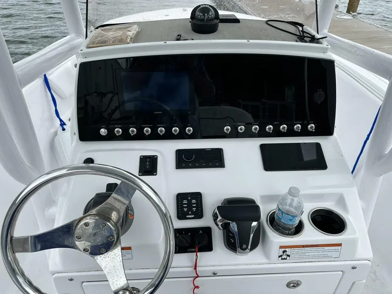 Slide: The Image of Control panel of a 2022 Sportsman 232 Open boat with steering wheel and navigation equipment. - 7