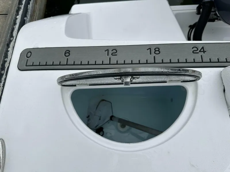 Slide: The Image of Sportsman 232 Open 2022 boat with open hatch and measuring ruler on deck. - 8