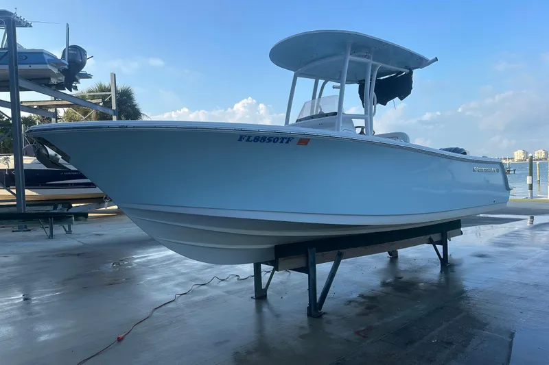 Slide: The Image of 2022 Sportsman Open 232 Center Console boat on a dock, under clear blue sky. - 4