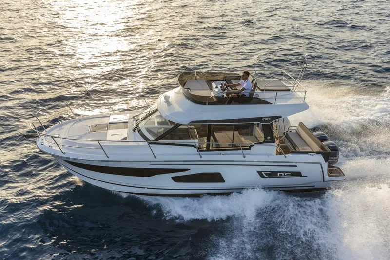Slide: The Image of 2025 Jeanneau NC 1095 Fly cruising on open water at sunset. - 0