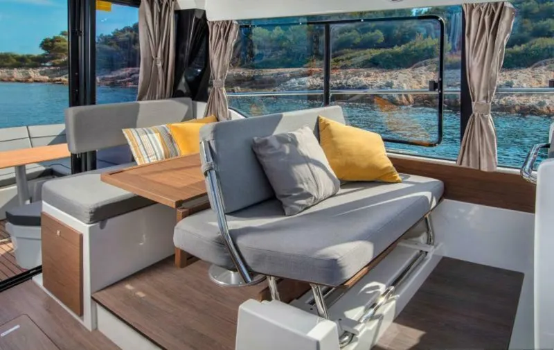 Slide: The Image of Interior of 2025 Jeanneau NC 1095 Fly yacht with cozy seating and scenic window view. - 5