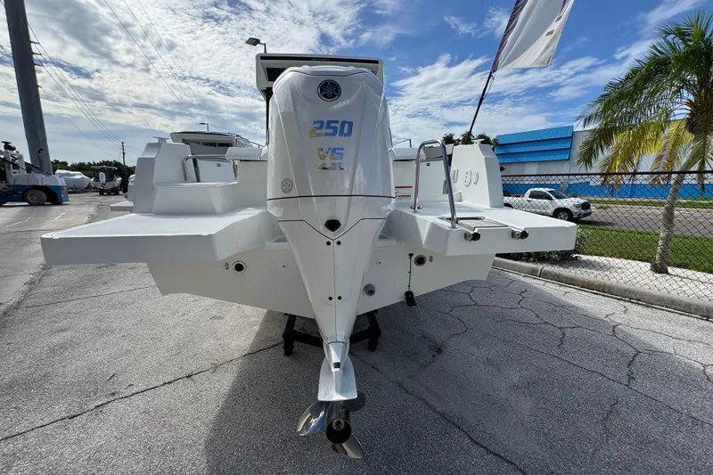 Slide: The Image of 2025 Jeanneau NC 795 SPORT S2 boat with powerful outboard motor, docked under a clear sky. - 1