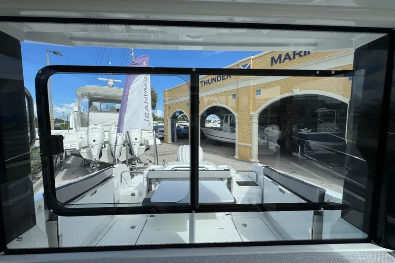 Slide: The Image of 2025 Jeanneau NC 795 SPORT S2 boat at marina, viewed through window. - 14