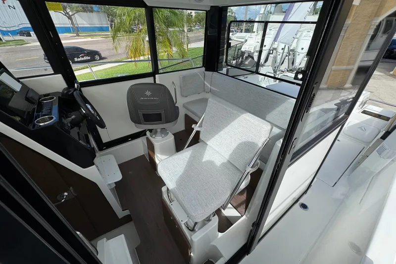 Slide: The Image of Interior of 2025 Jeanneau NC 795 SPORT S2 boat, featuring helm and seating area. - 8