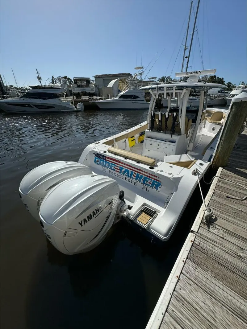 Slide: The Image of A 2023 Sportsman boat docked with twin Yamaha engines in a marina. - 13