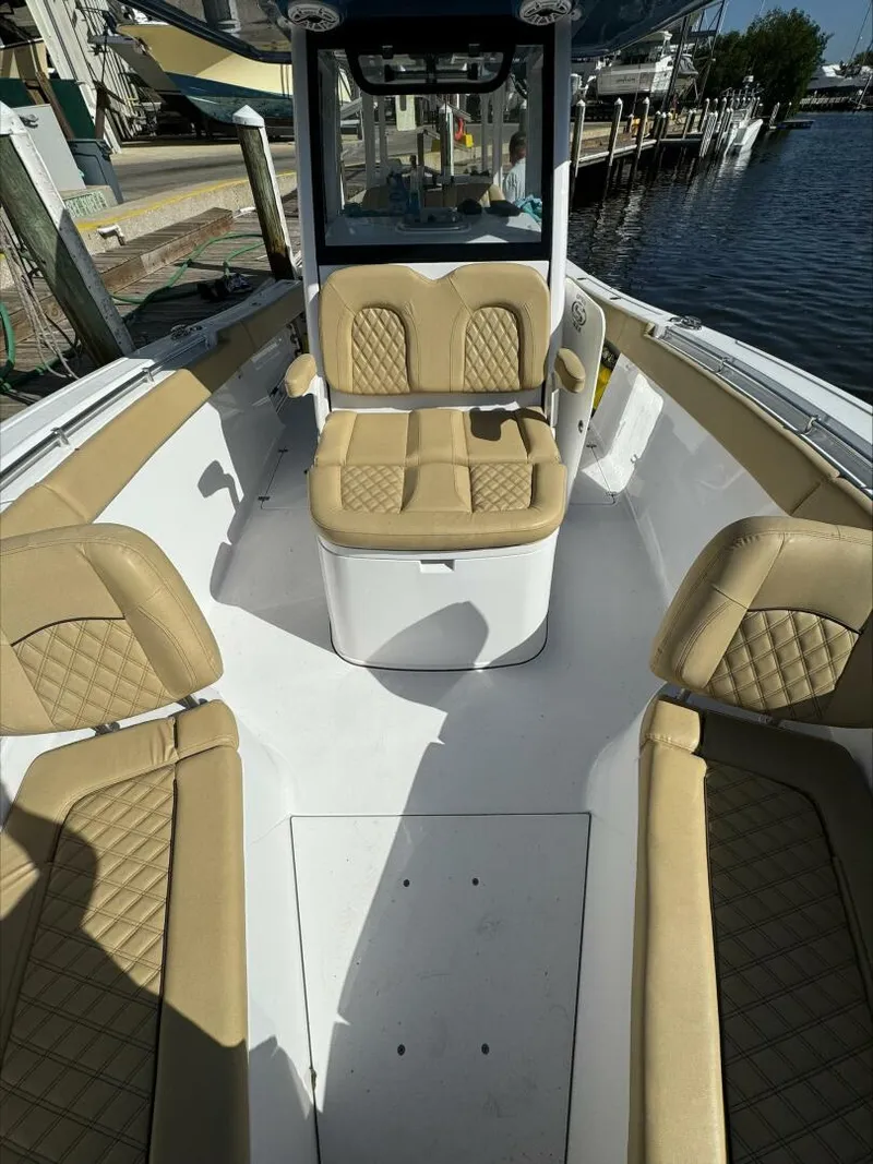 Slide: The Image of 2023 Sportsman boat interior with tan quilted seats, docked by the water. - 17