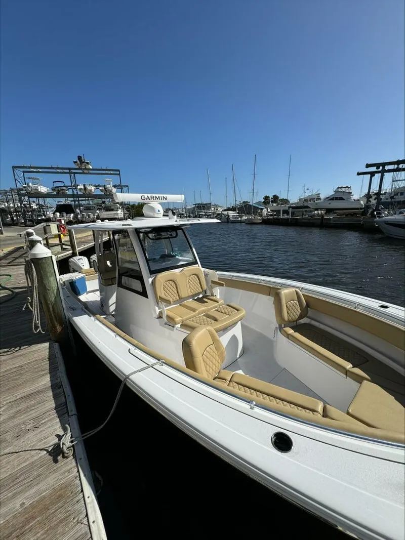 Slide: The Image of 2023 Sportsman boat docked at marina with tan seating and clear blue sky. - 19