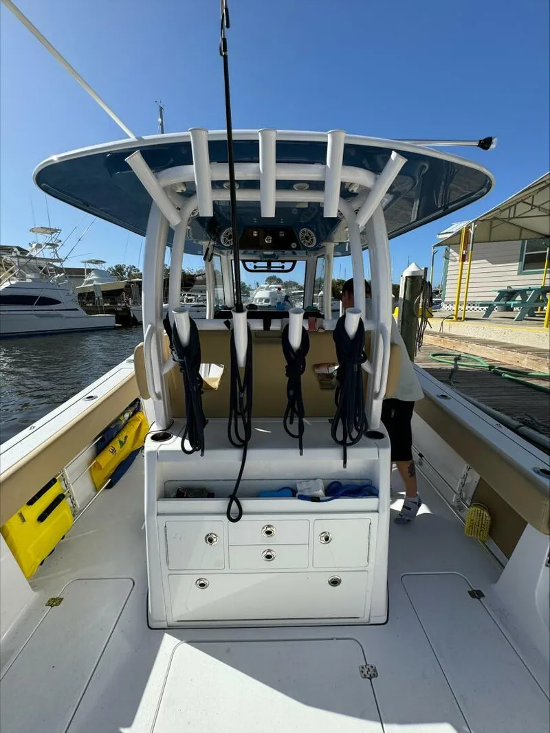 Slide: The Image of 2023 Sportsman boat interior with fishing rod holders and storage, docked at marina. - 22