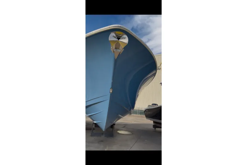 Slide: The Image of 2023 Sportsman Open 322 Center Console boat, blue hull, docked outdoors. - 27