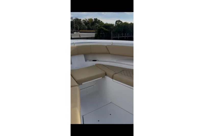 Slide: The Image of 2023 Sportsman Open 322 Center Console boat interior with tan seating and white deck. - 34