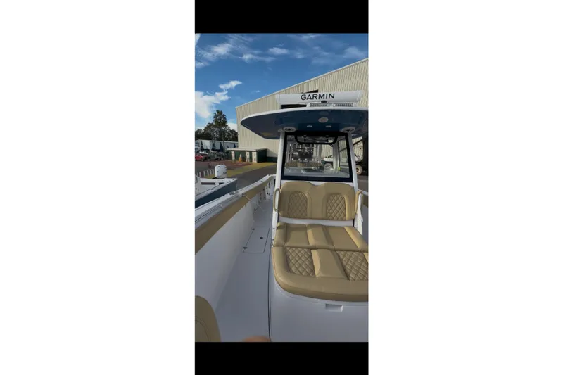Slide: The Image of 2023 Sportsman Open 322 Center Console boat with tan seating and Garmin equipment. - 39