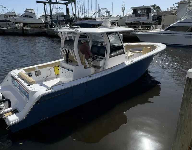 Slide: The Image of 2023 Sportsman boat docked at marina with other vessels in background. - 4