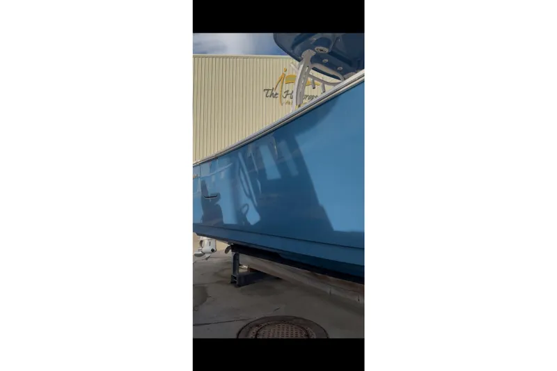 Slide: The Image of 2023 Sportsman Open 322 Center Console boat in blue, displayed outdoors. - 41