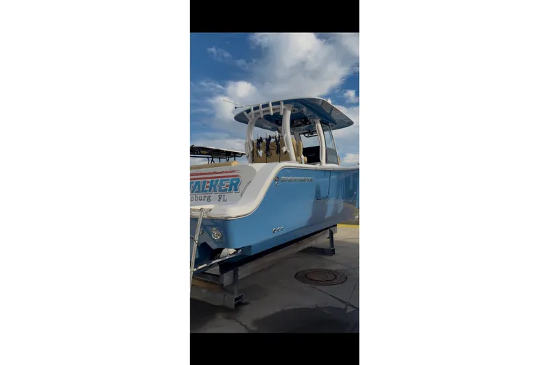 Slide: The Image of 2023 Sportsman Open 322 Center Console boat in blue, docked under a cloudy sky. - 42