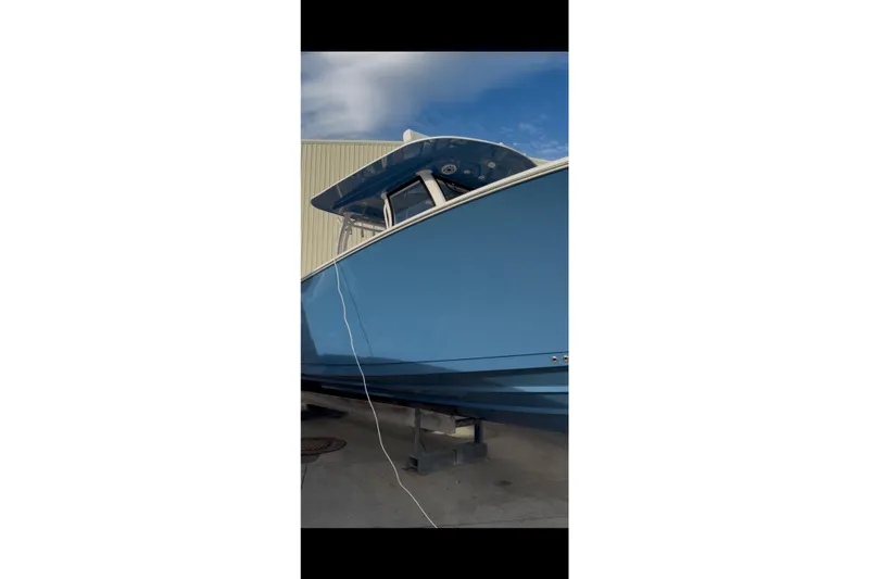 Slide: The Image of 2023 Sportsman Open 322 Center Console boat in blue, docked outdoors. - 45