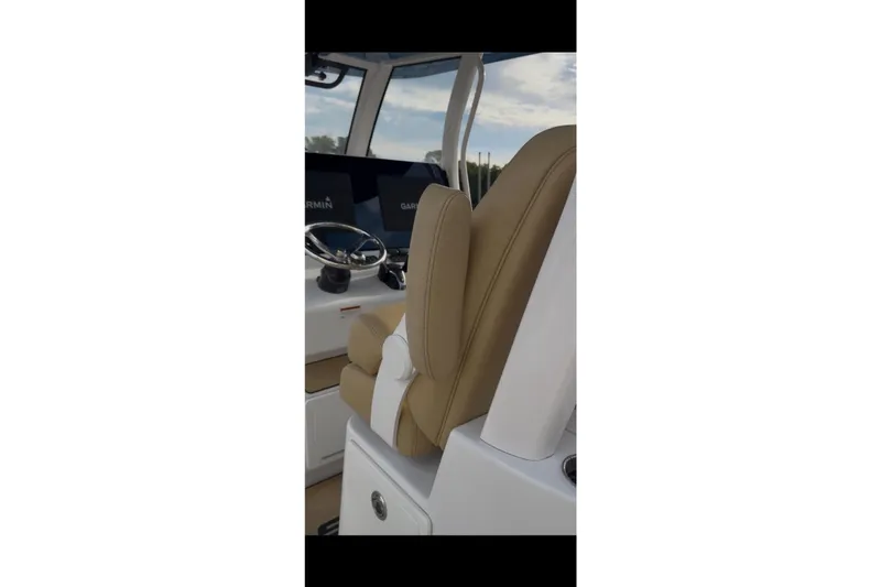 Slide: The Image of 2023 Sportsman Open 322 Center Console helm with tan seating and Garmin displays. - 47