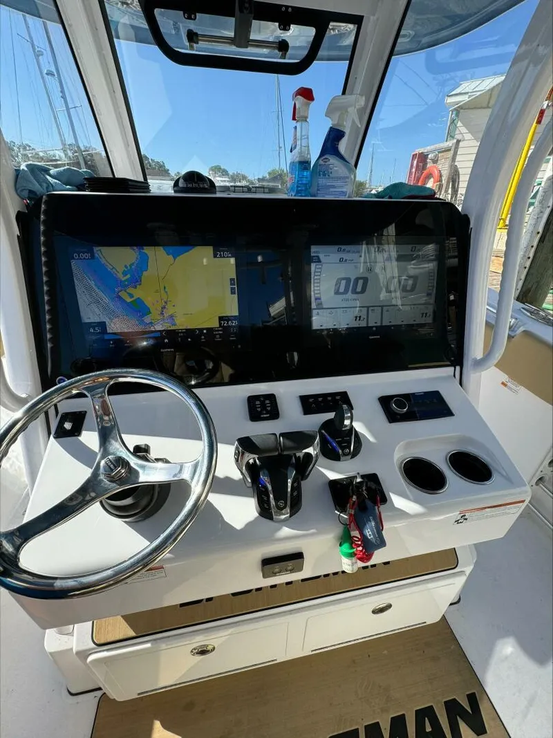 Slide: The Image of Boat cockpit with navigation screens, steering wheel, and controls, Sportsman 2023 model. - 8