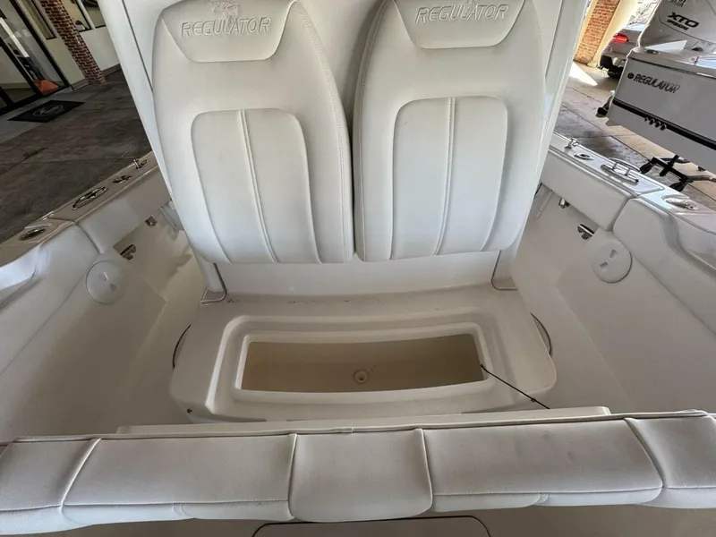 Slide: The Image of 2025 Regulator 24 XO boat interior with white seating and storage compartment. - 15