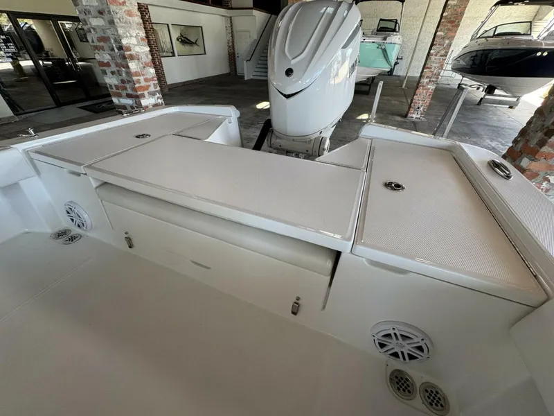 Slide: The Image of 2025 Regulator 24 XO boat interior with storage compartments and outboard motor in showroom. - 5
