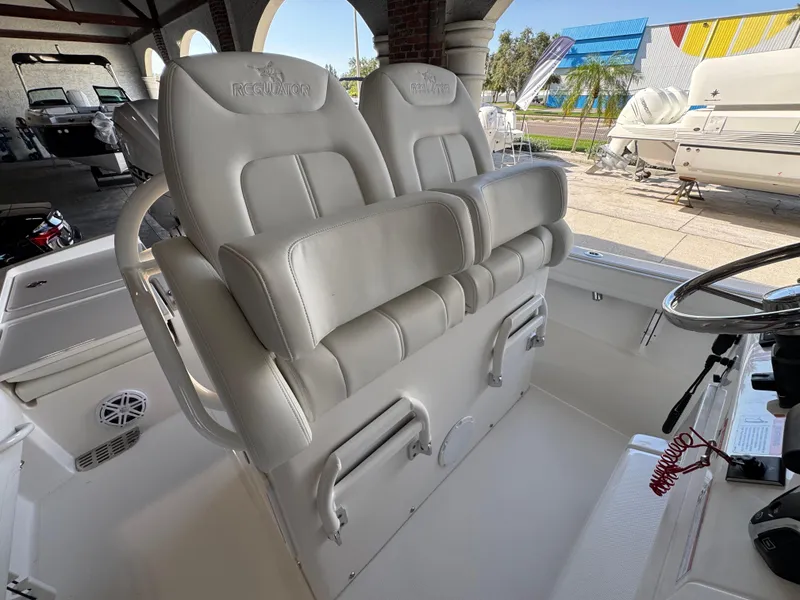 Slide: The Image of 2025 Regulator 26XO boat interior with dual white cushioned seats and steering wheel. - 10