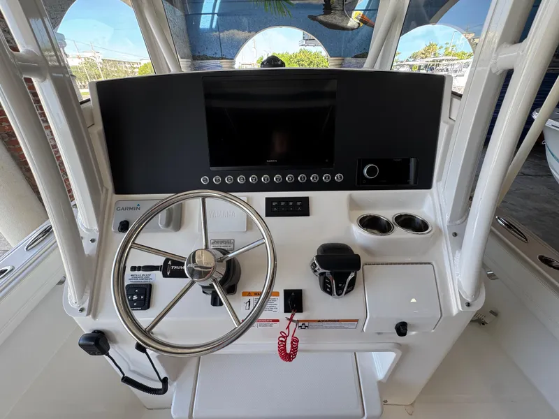 Slide: The Image of 2025 Regulator 26XO boat dashboard with steering wheel, Garmin display, and control panel. - 12