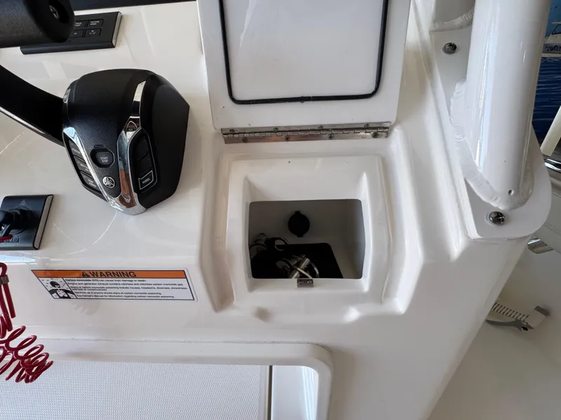 Slide: The Image of 2025 Regulator 26XO boat console with controls and storage compartment. - 13