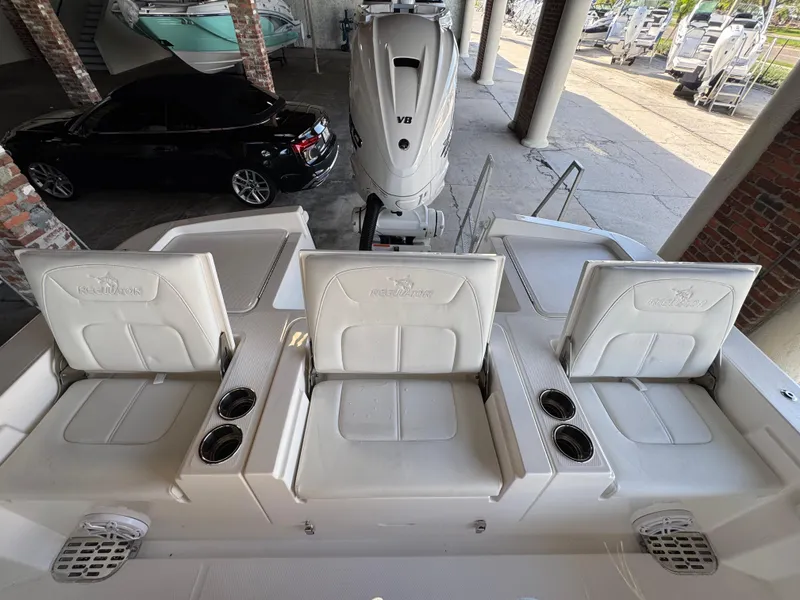 Slide: The Image of 2025 Regulator 26XO boat seats with cup holders and V8 engine in a showroom. - 5