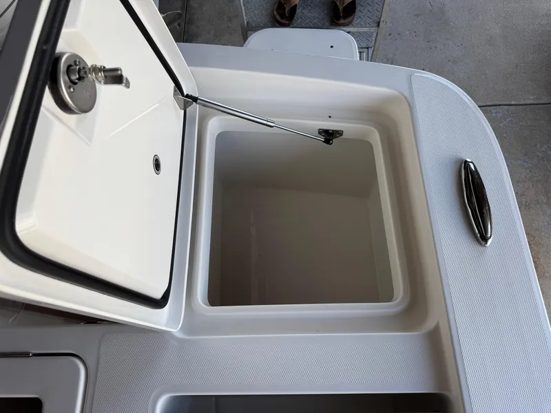 Slide: The Image of Open storage compartment on 2025 Regulator 26XO boat, featuring a secure latch and hydraulic support. - 6