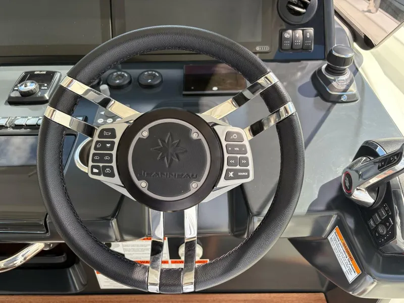 Slide: The Image of Steering wheel of 2024 Jeanneau DB43 boat with control buttons and dashboard. - 12