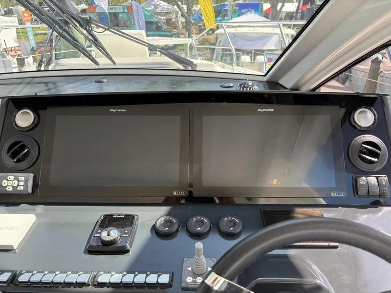 Slide: The Image of 2024 Jeanneau DB43 helm with dual Raymarine displays and control panel. - 13