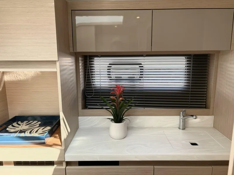Slide: The Image of Modern kitchen area in 2024 Jeanneau DB43 yacht with sleek cabinetry and potted plant. - 19