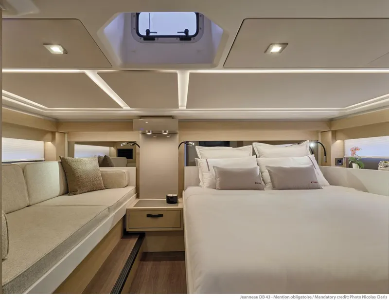 Slide: The Image of Luxurious interior of 2024 Jeanneau DB43 yacht with elegant bedding and seating. - 23